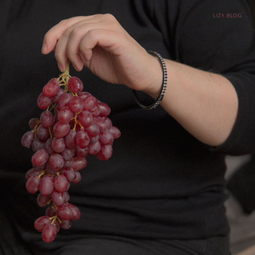 Holding a bunch of juicy grapes.
