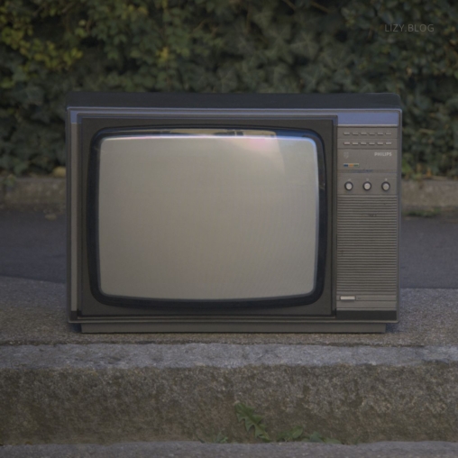 A discarded TV set on a street corner.