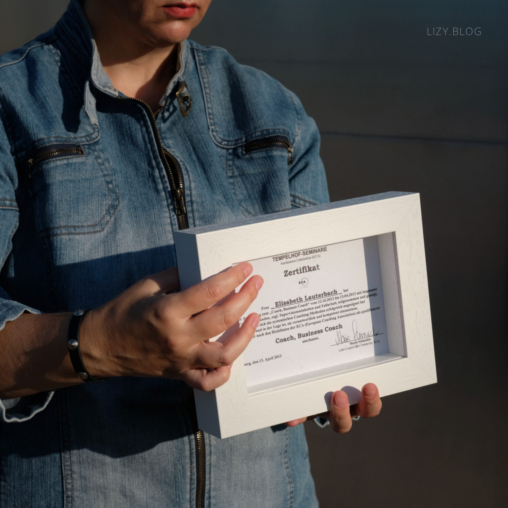 Elisabeth is holding a framed certificate.