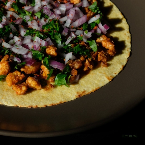 Tofu crumble on tortilla with onions and herbs.