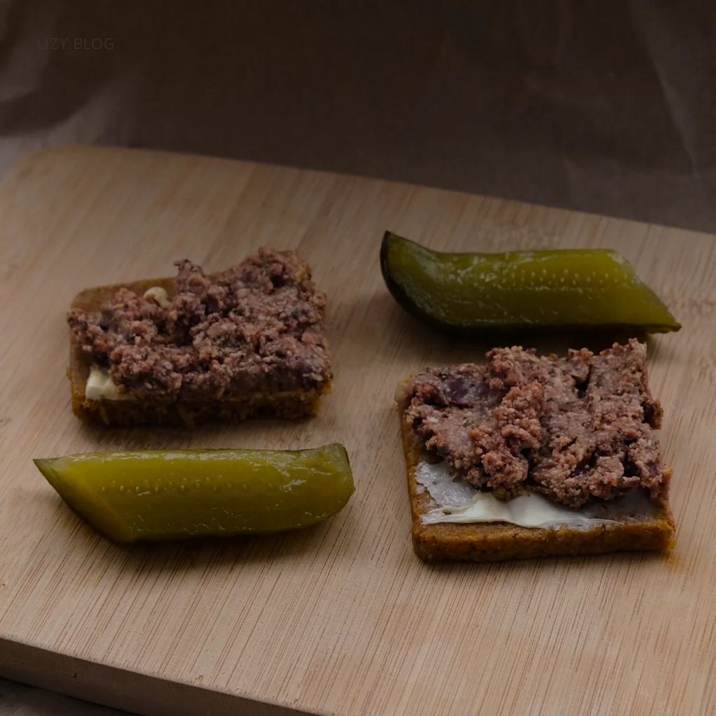 Meatless pate on bread with pickles on the side.